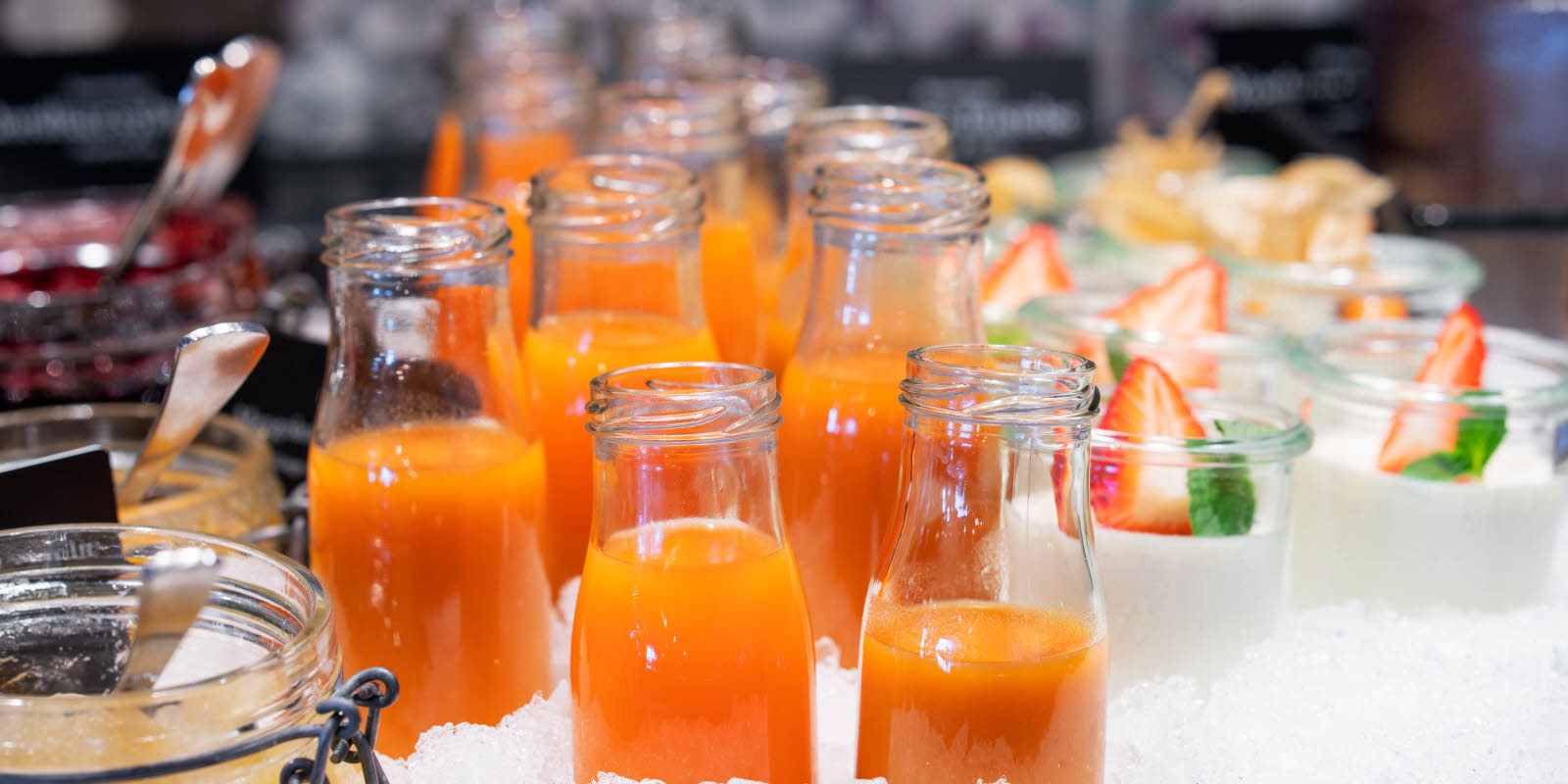 Small glass bottles filled with a homemade, orange colored vegetable juice.