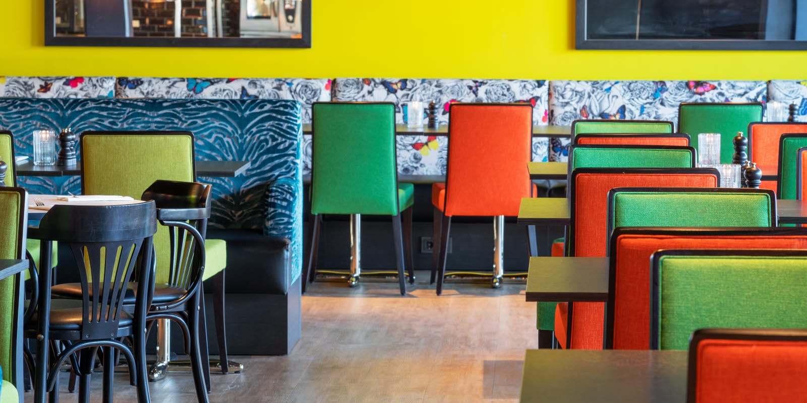 Restaurang med sittplatser, gula väggar och färgglada möbler på Thon Hotel Triaden i Lørenskog
