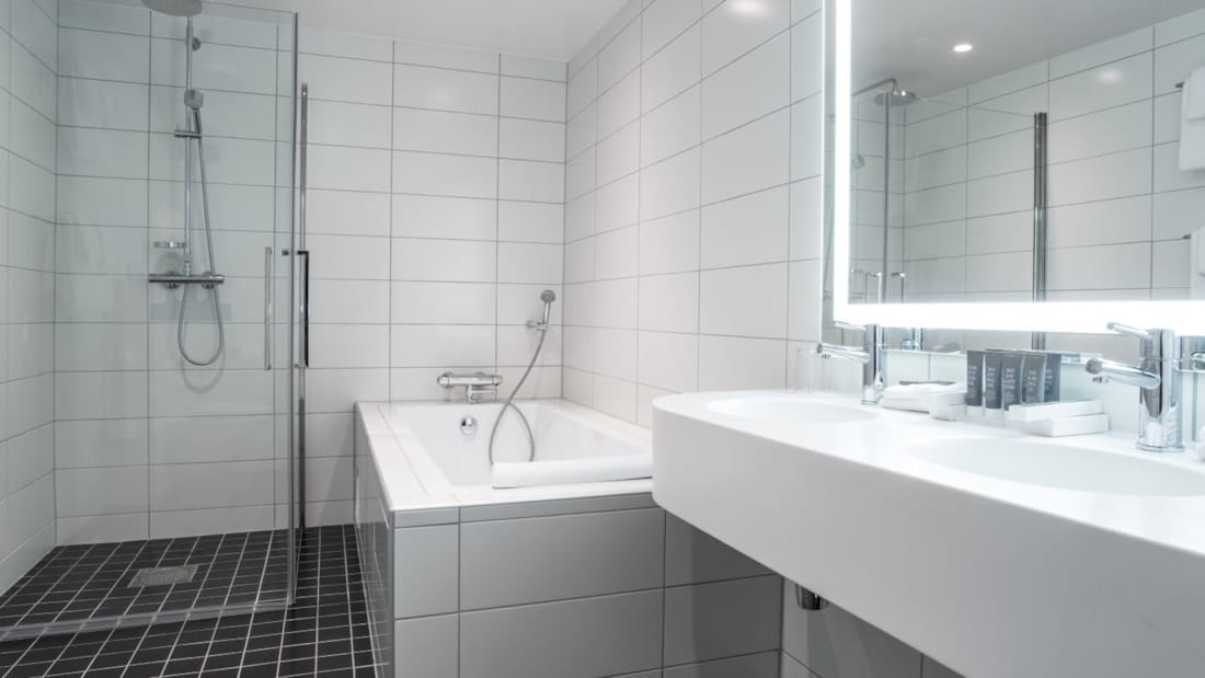 Badeværelse med badekar, bruser og dobbeltvask i business room på Thon Hotel Triaden i Lørenskog
