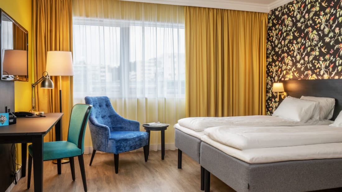 Tv, sittområde och säng i superiorrum på Thon Hotel Triaden