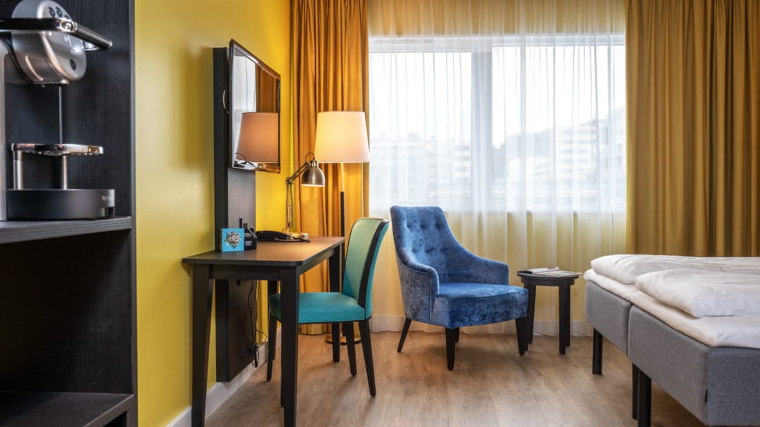 TV, sitteområde samt seng i Superior Room ved Thon Hotel Triaden