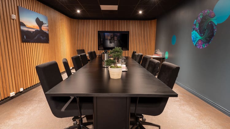 Meeting room with long table and wall-mounted TV