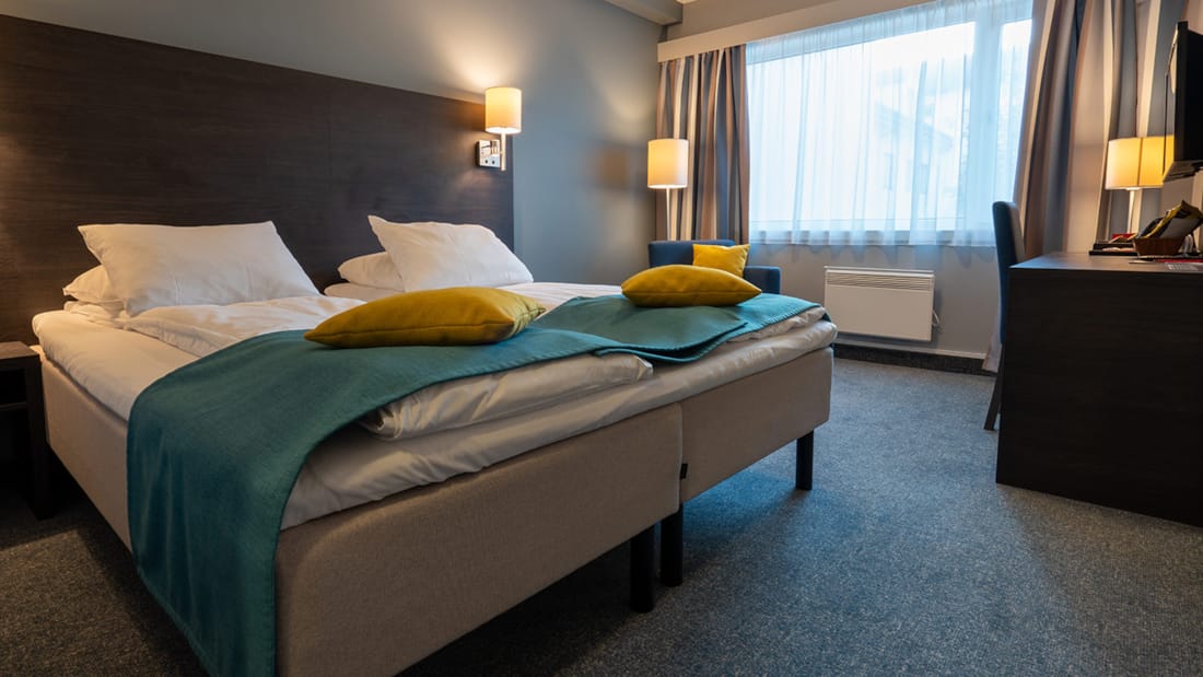 Säng i standarddubbelrum på Hotel Måløy