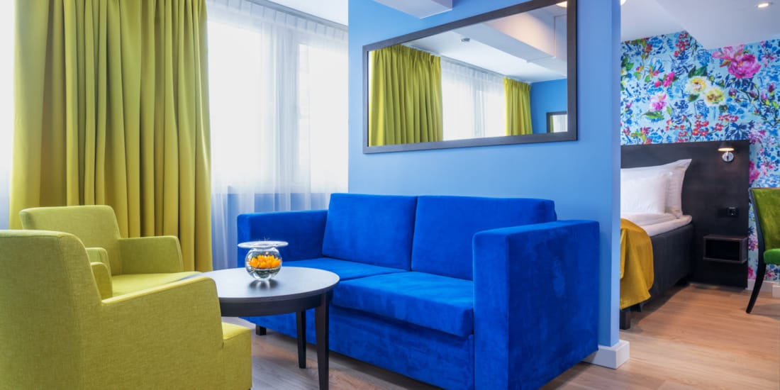 Sittegruppe med gule stoler og blå sofa  i business rom på Thon Hotel Moldefjord