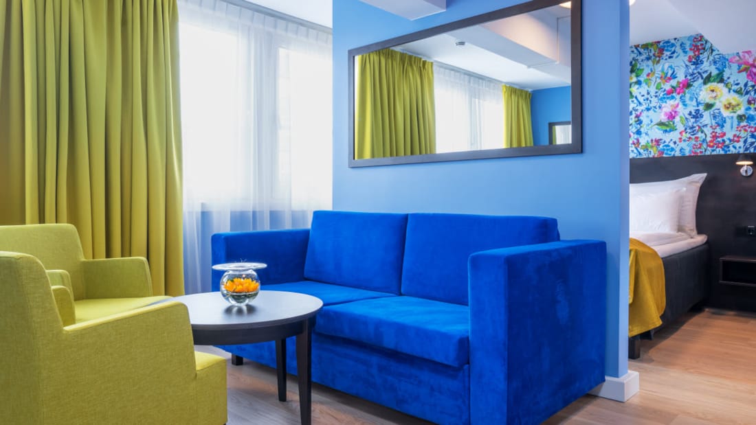 Siddegruppe med gule stole og blå sofa i business værelse på Thon Hotel Moldefjord