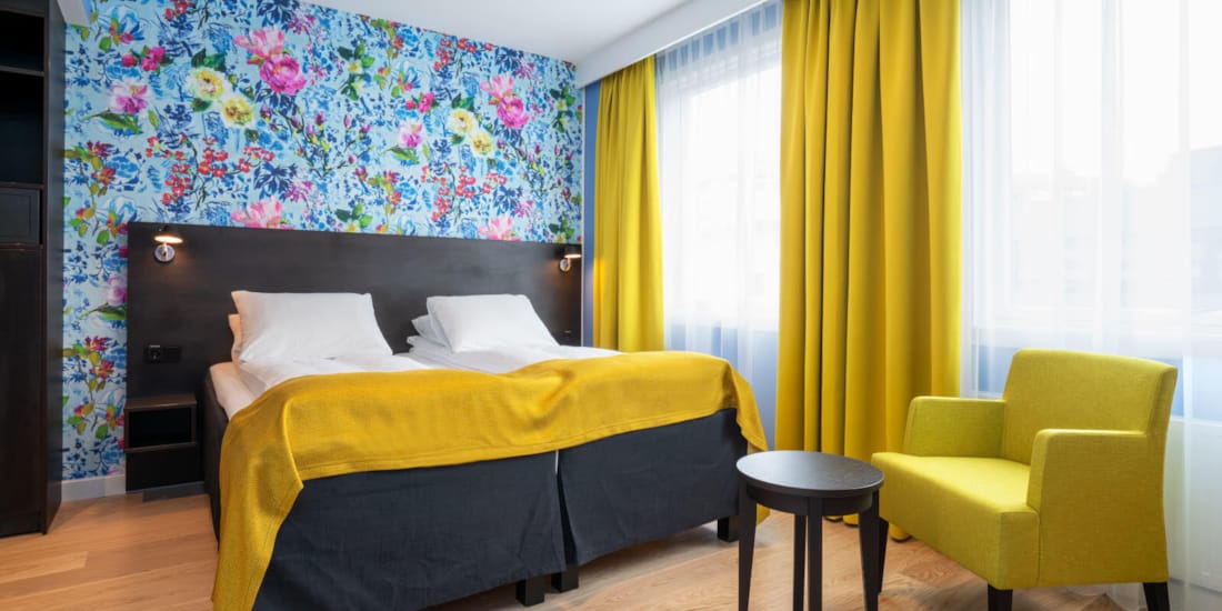 Separate senger, blomstrete tapet og gule gardiner i twin rom på Thon Hotel Moldefjord