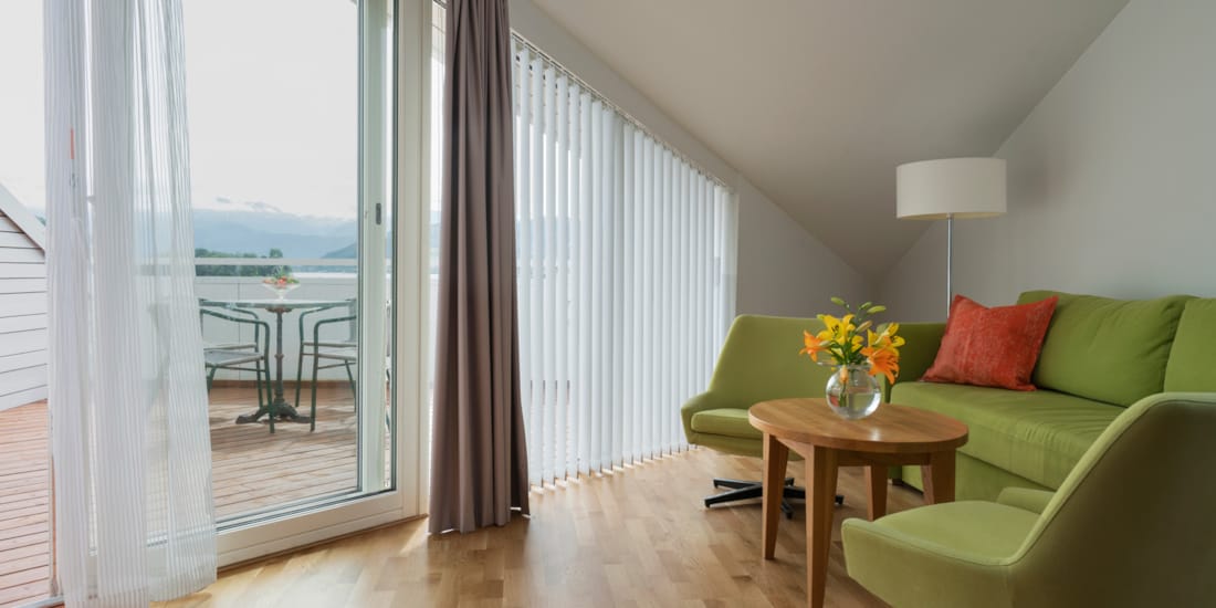 Toroms leilighet med sofa og verandadør ut mot veranda på Thon Hotel Sandven i Nordheimsund