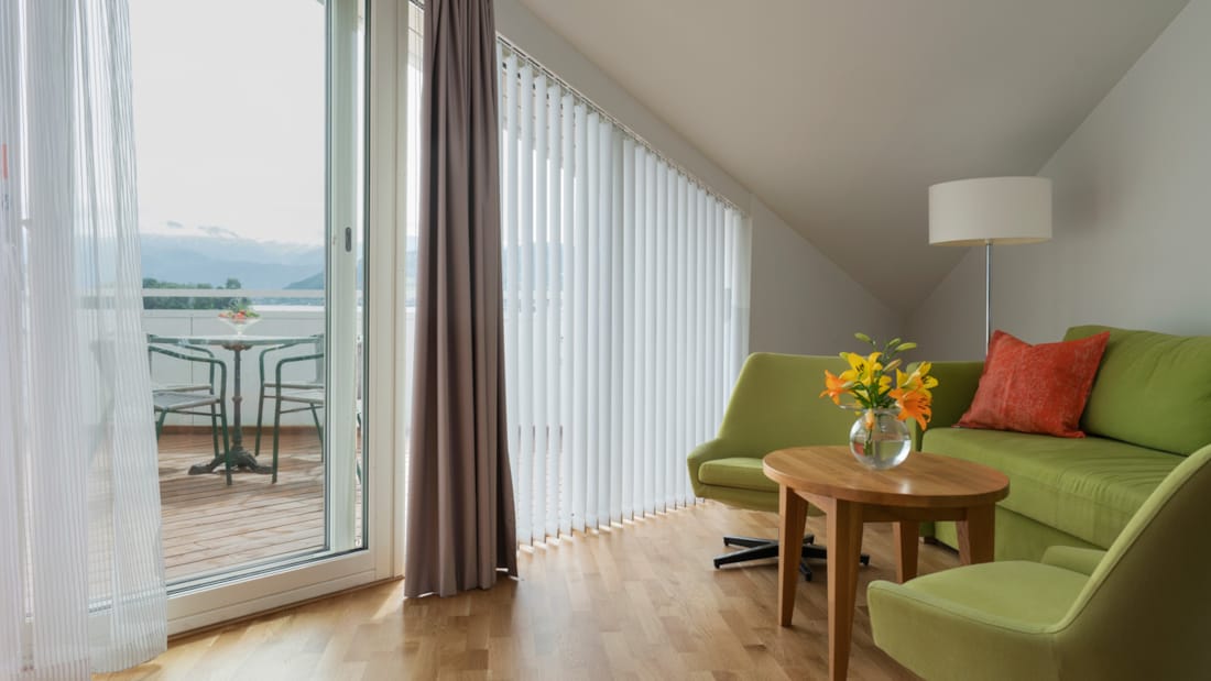 2-rumslägenhet med soffa och dörr ut mot veranda på Thon Hotel Sandven i Nordheimsund