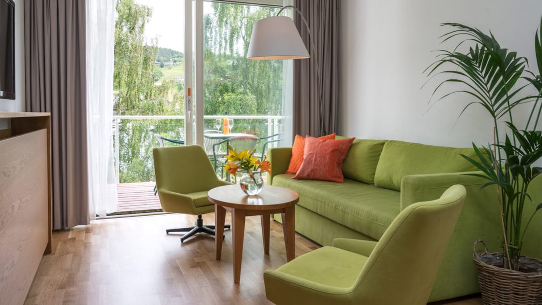 Blomster på bord i stue med sofa og to stole på Thon Hotel Sandven i Nordheimsund