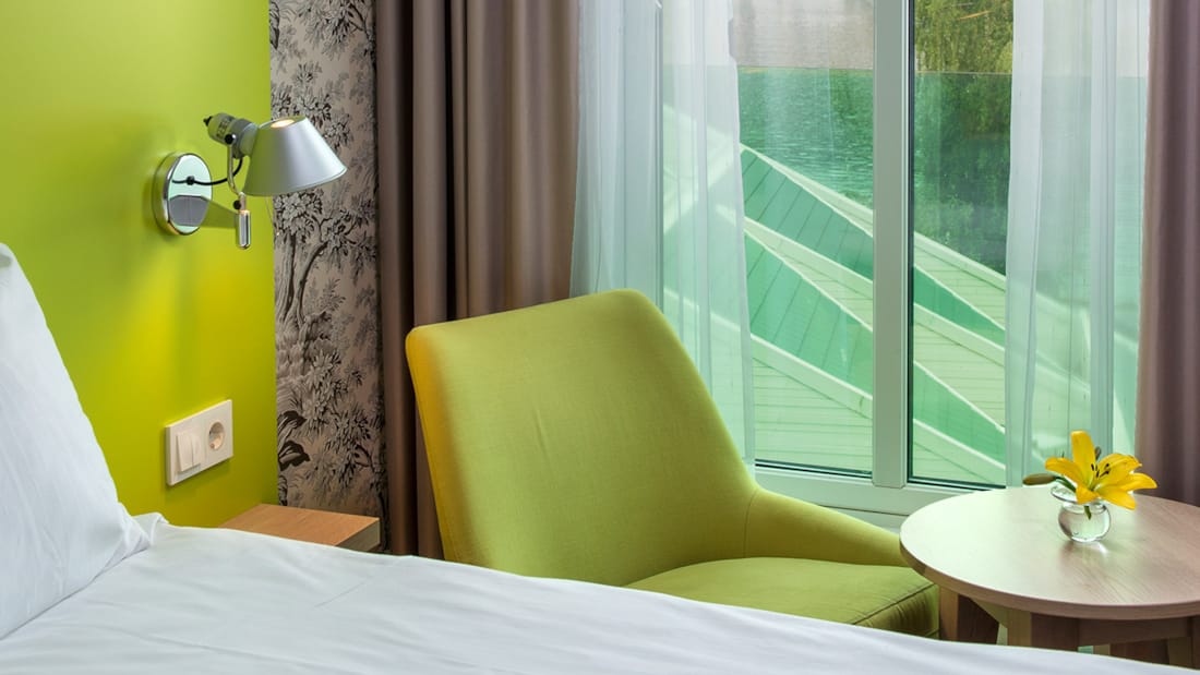 Säng och bord med utsikt på Thon Hotel Sandven