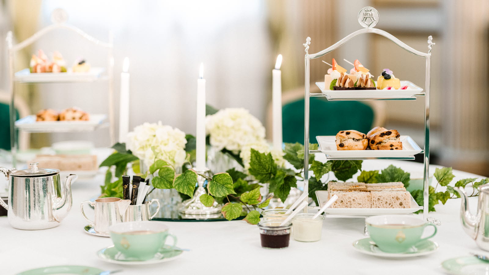 Thon Hotel Bristol dekket bord med bakevarer, tee, blomster og lys
