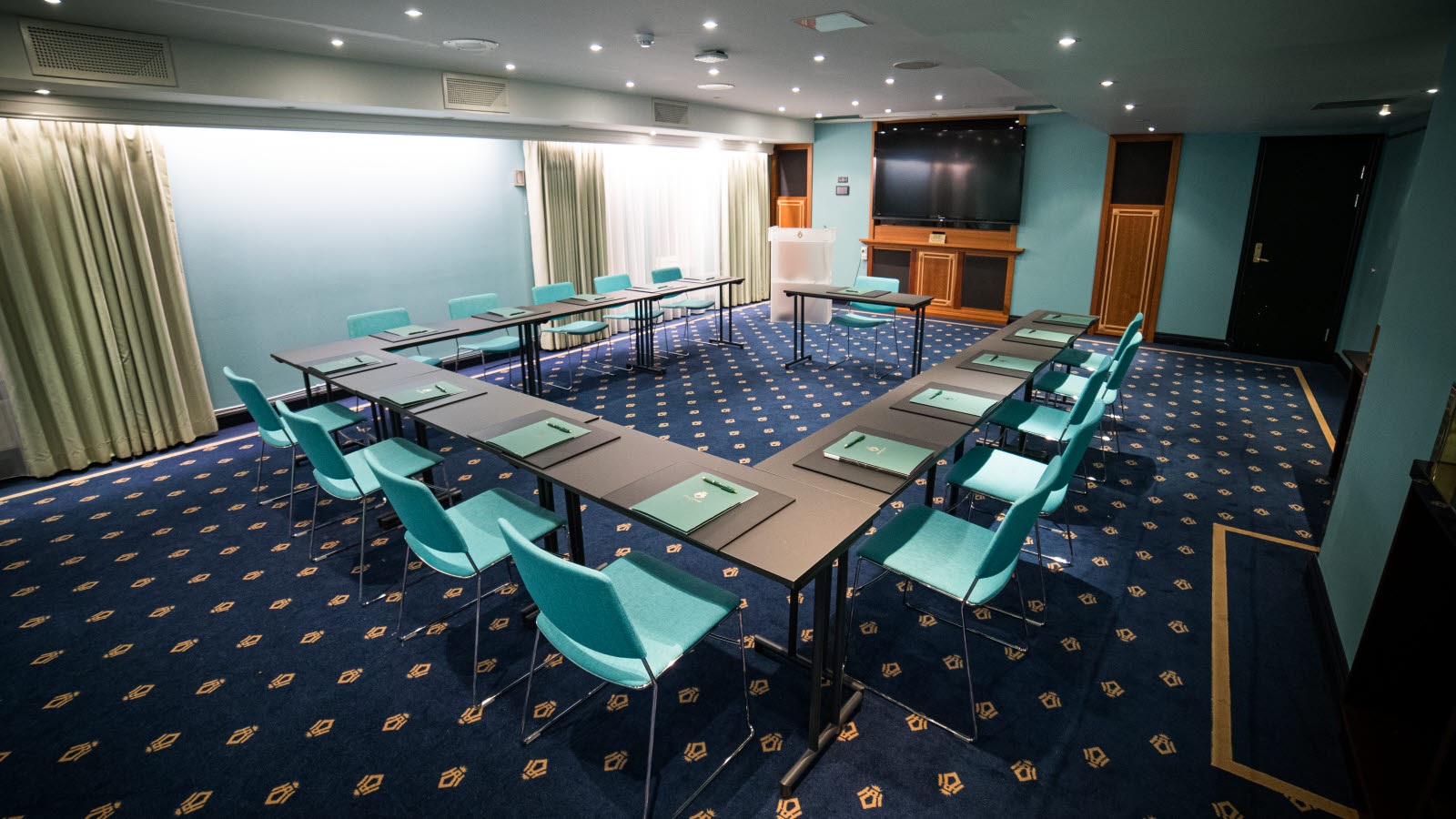 Conference room with U-shaped table with wall-mounted TV