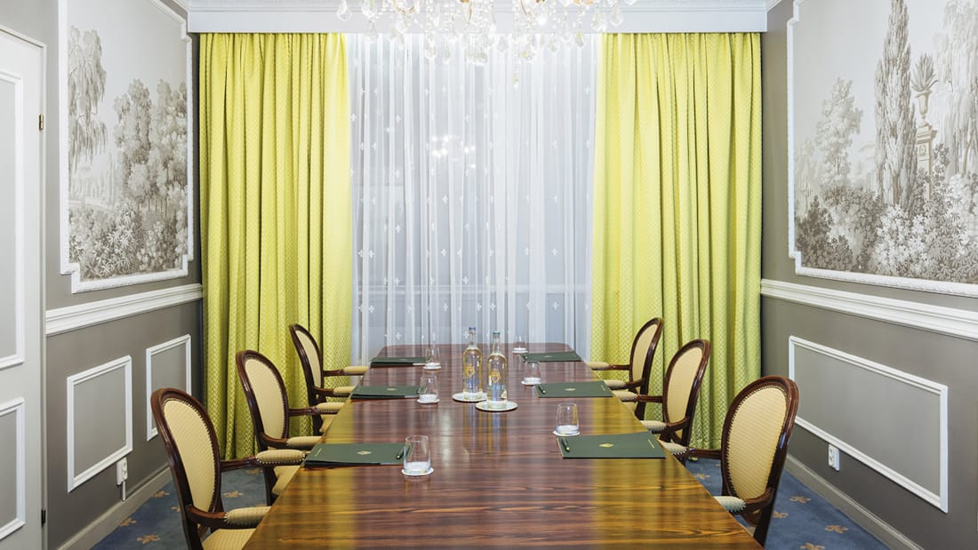 Salle de réunion avec grande fenêtre, longue table et chaises