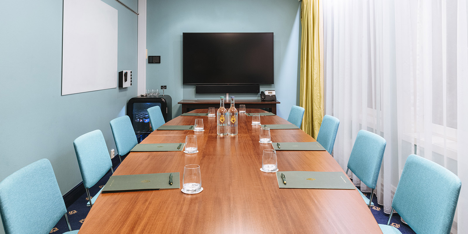Meeting room with large window, long table and chairs