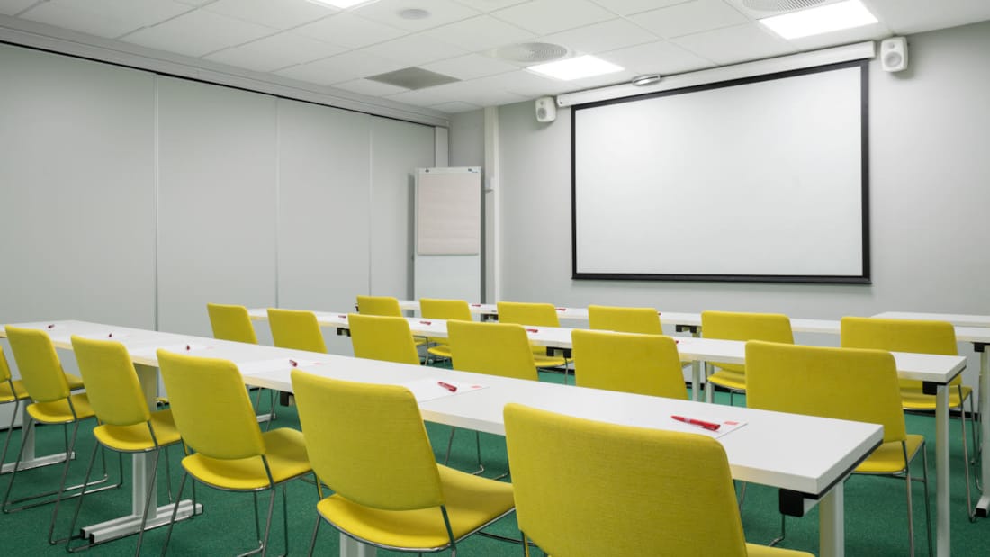 Vergaderruimte in klaslokaalopstelling met projector