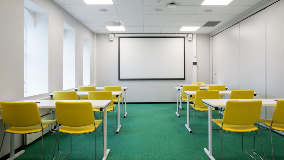 Litet mötesrum i klassrumslayout med projektor
