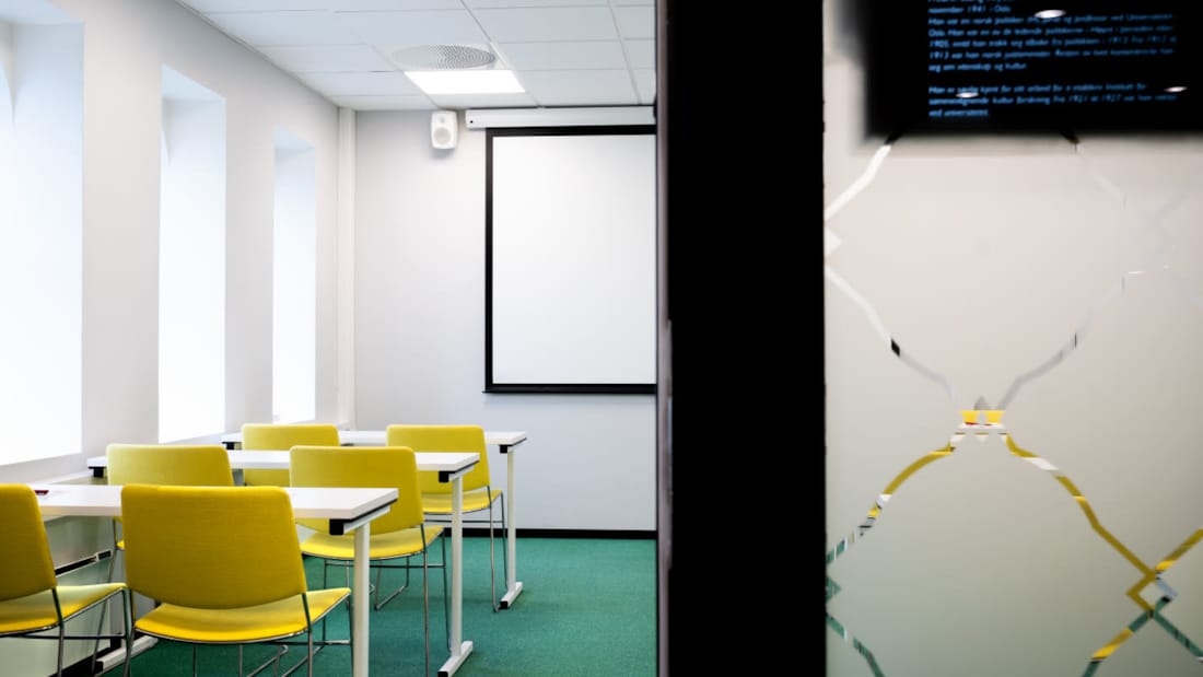Detaljbild av mellanvägg och klassrumsmöblering i konferensrummet Stang