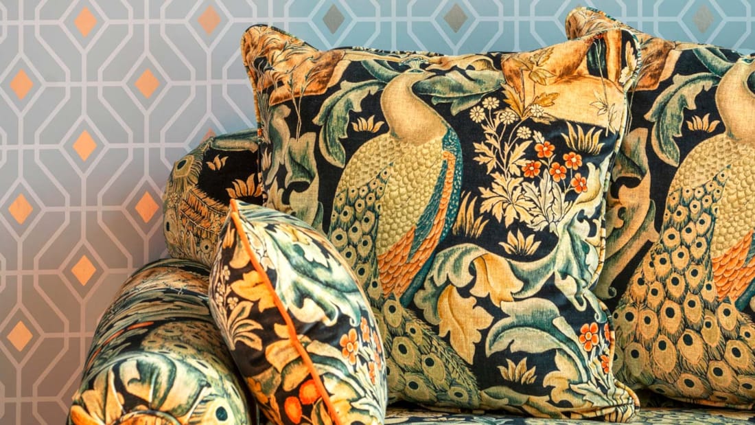 Detaljbilde av sofa med mønstret tapet og jungelinspirert sofa på Thon Hotel Cecil