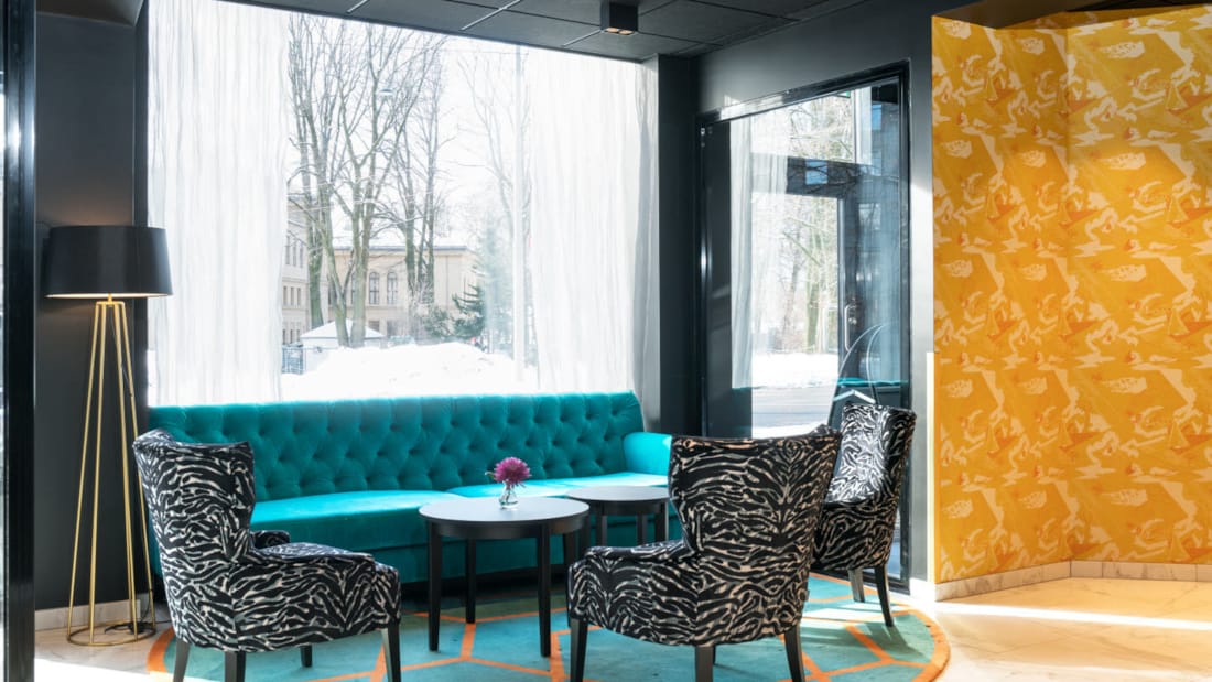 Receptionsområde/lobby med zebrarandiga fåtöljer och en stor soffa på Thon Hotel Europa i centrala Oslo precis vid Slottsparken