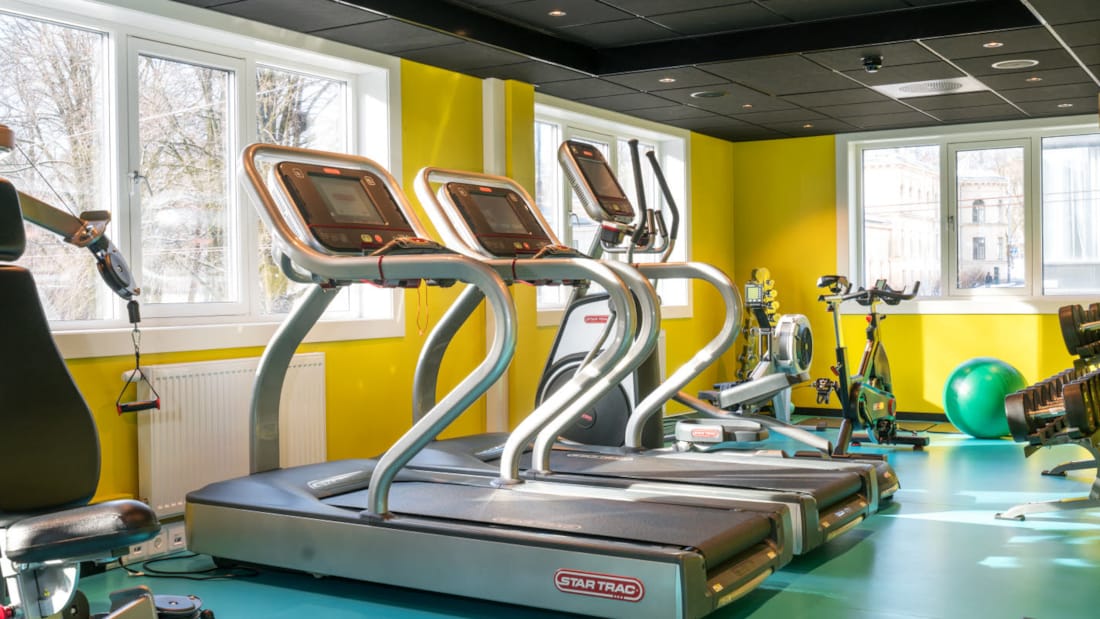 Fitness-rum med forskellige træningsmaskiner med gule vægge og turkis gulv på Thon Hotel Europa i Oslo centrum lige ved Slottsparken
