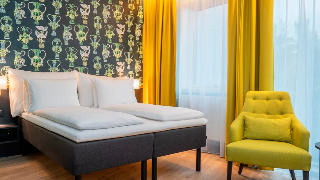 Säng och stol i businessrum på Thon Hotel Linne i Oslo