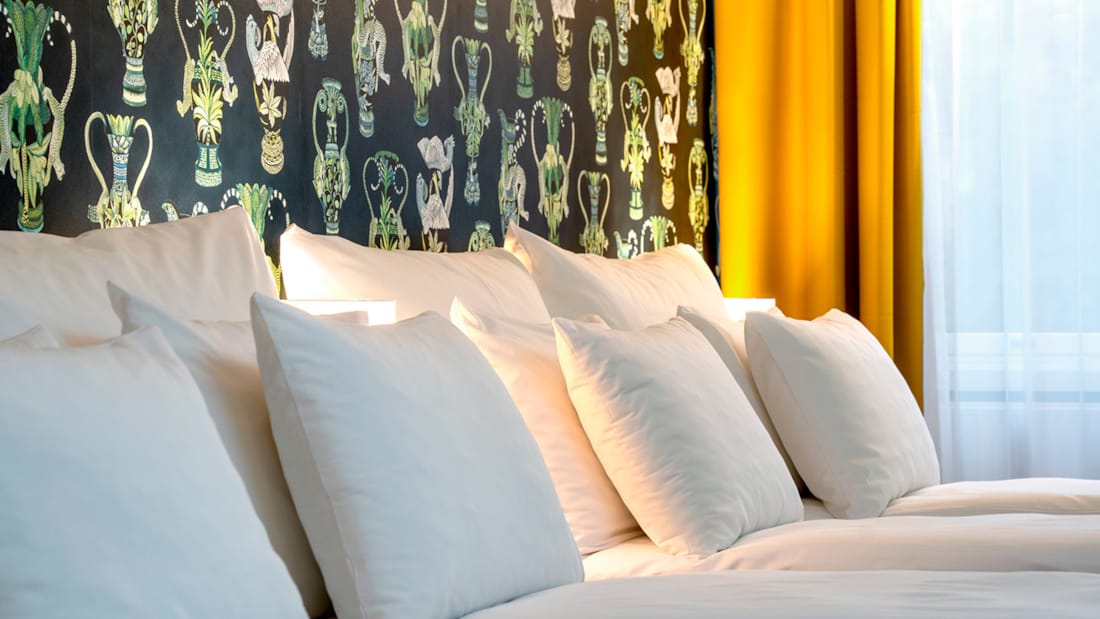 Stor seng, sittegruppe og spisebord i junior suite på Thon Hotel Linne i Oslo