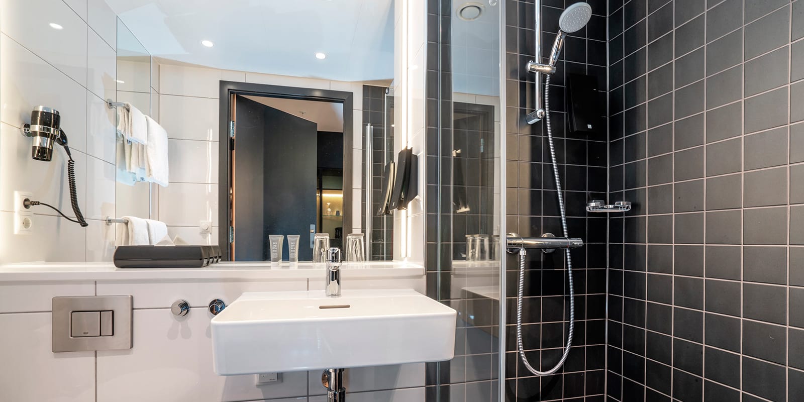 Badrum med dusch, toalett och handfat i juniorsvit på Thon Hotel Linne i Oslo