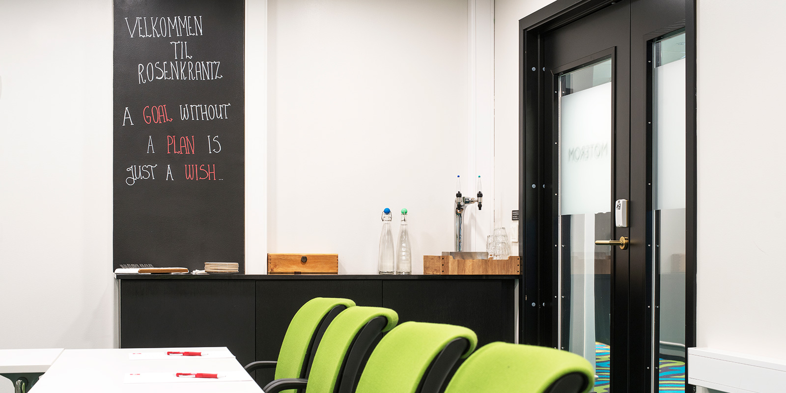 Mødelokale med 12 pladser foran projektorlærredet