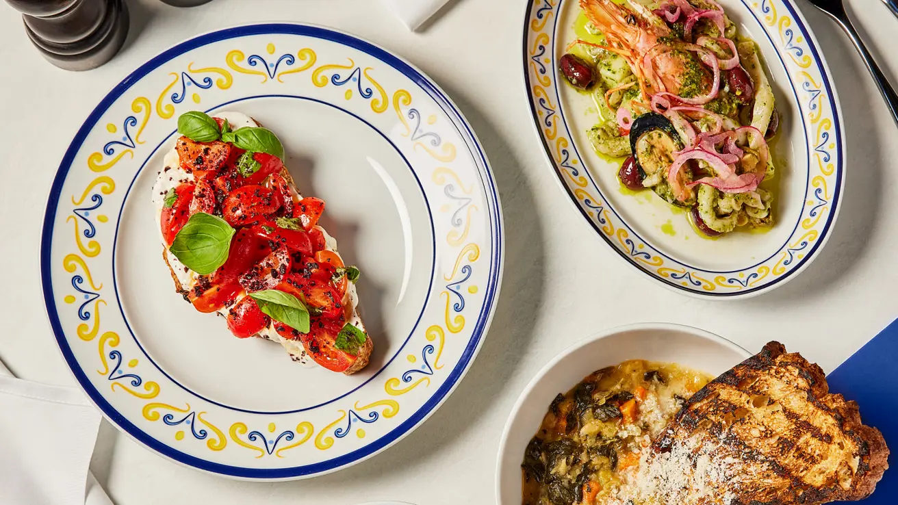 Utsnitt av tre forskjellige italienske retter på et hvitt bord på Osteria della Nonna.