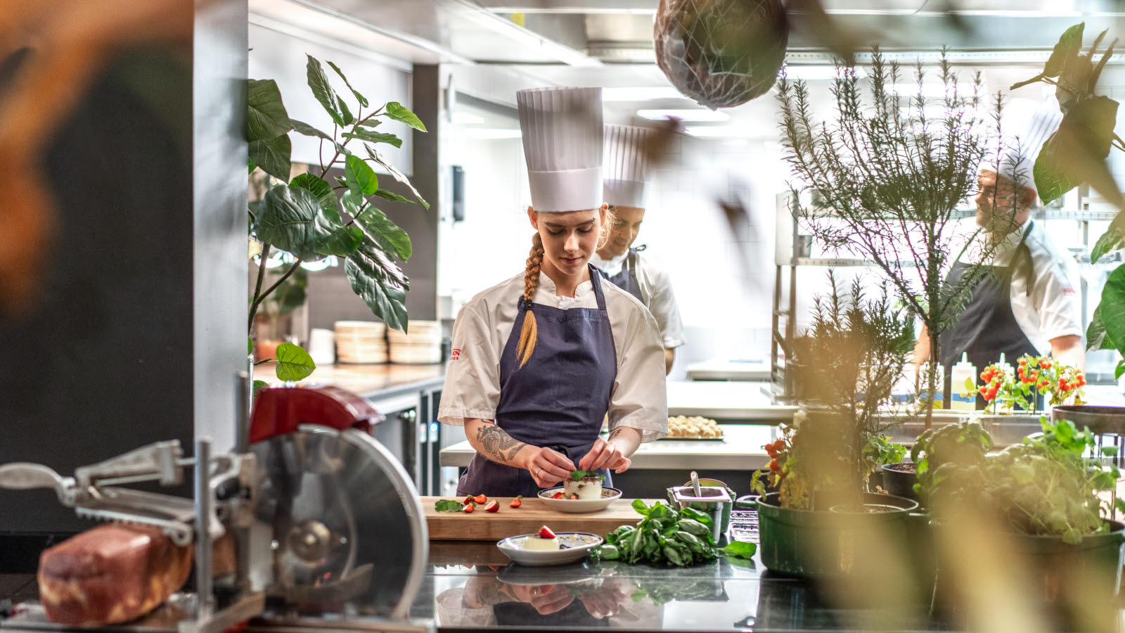 Kokk som lager mat på et åpent kjøkken, sett fra restauranten.