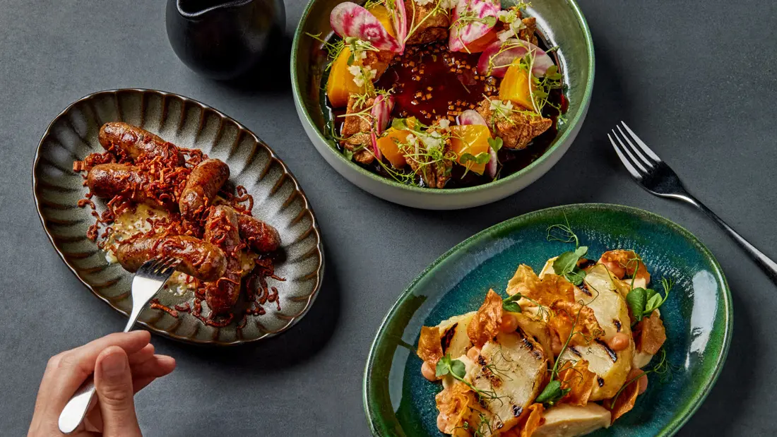 Ulike retter på et bord med lys duk, sett ovenfra.