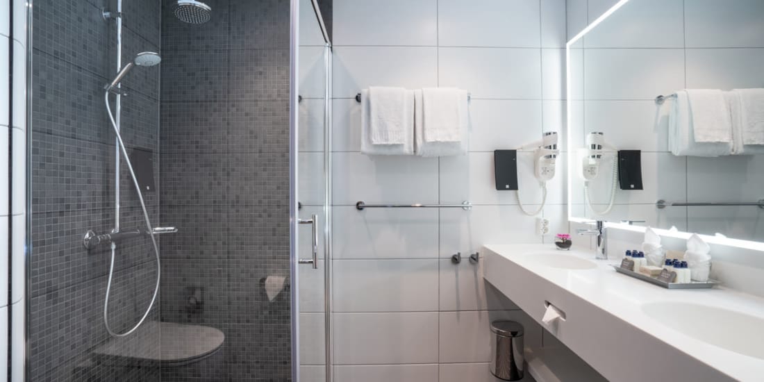 Stort og romslig bad med dusj og dobbelt servant på suite på Thon Hotel Storo i Oslo