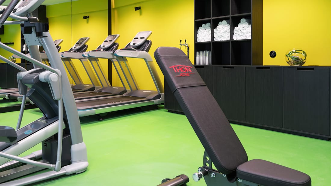 Løbebånd og styrketræningsmaskiner i fitness-rum