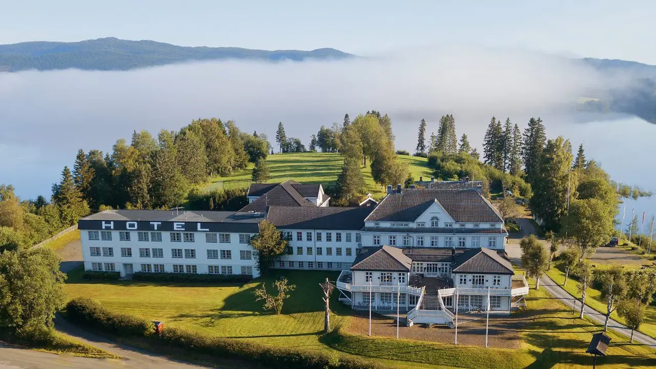 Hotel omgitt av trær og vann