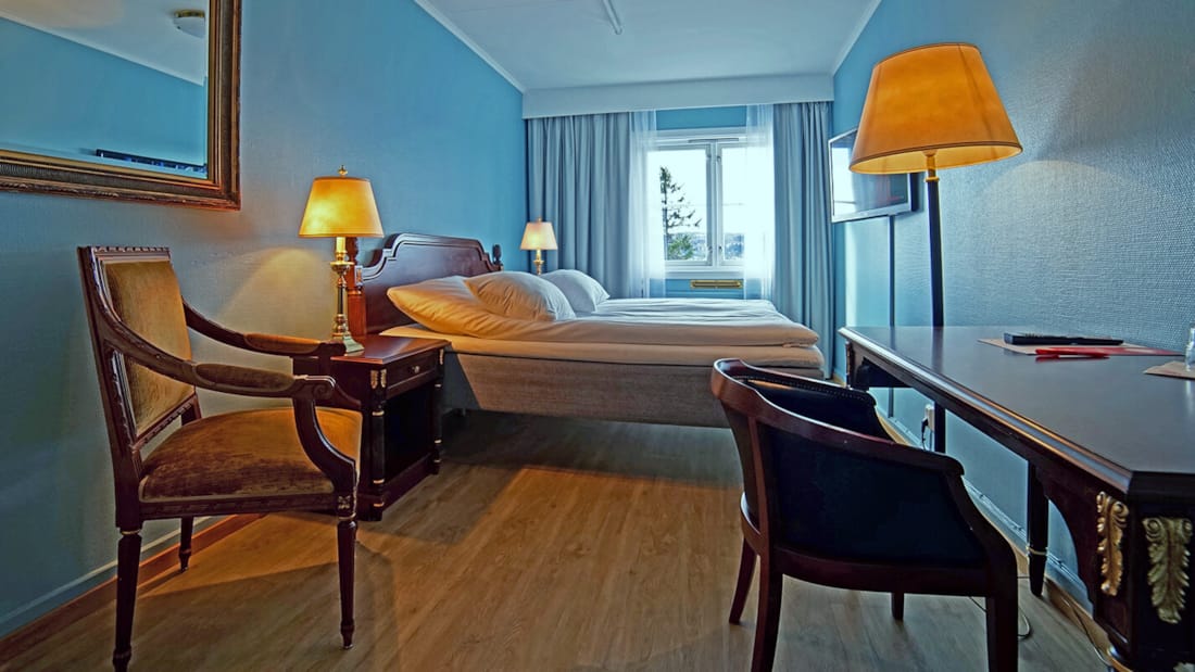 Säng, stol och skrivbord i rum på Thon Hotel Skeikampen
