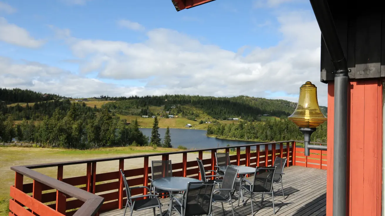 Veranda mit Aussicht auf die Berge, Sitzplätze und Sonne an der Berghütte Austlid Fjellstue, die zum Thon Hotel Skeikampen gehört