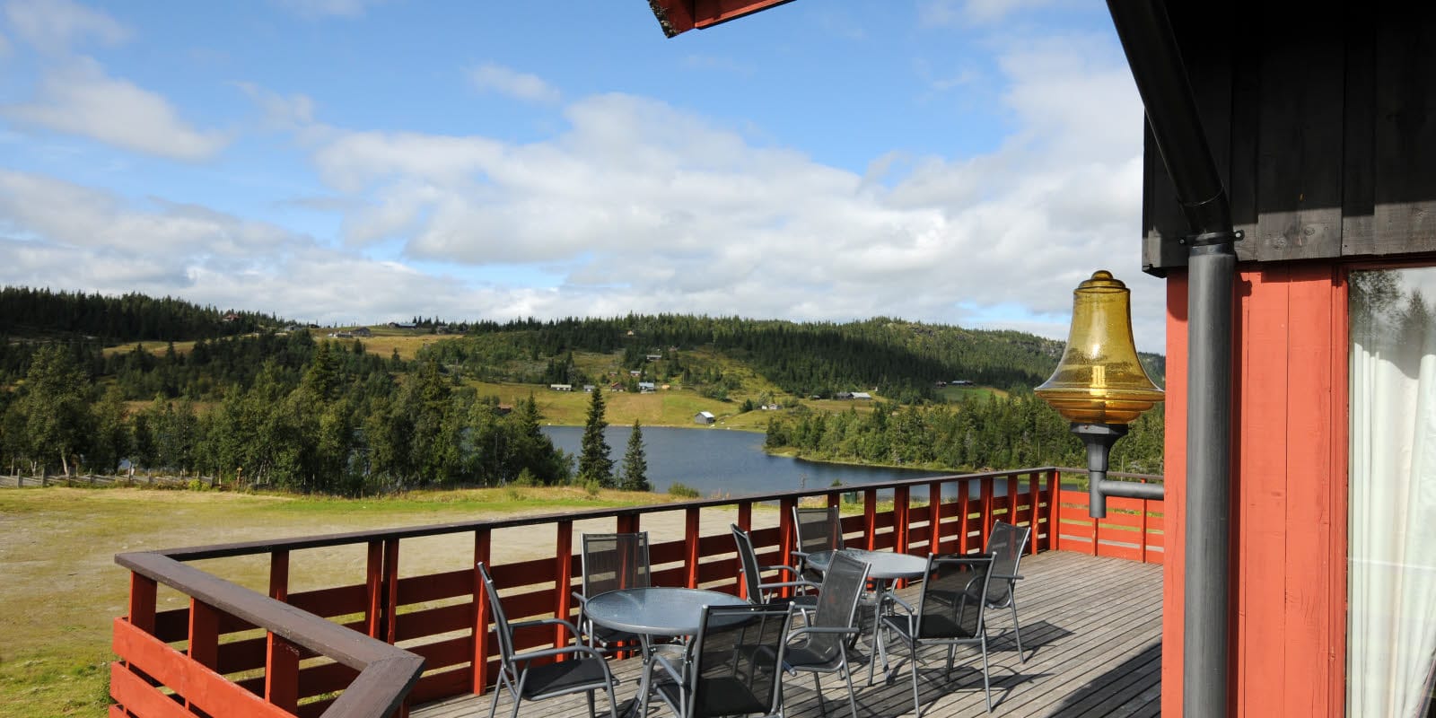 Veranda mit Aussicht auf die Berge, Sitzplätze und Sonne an der Berghütte Austlid Fjellstue, die zum Thon Hotel Skeikampen gehört