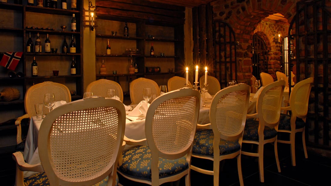 Dækket bord vinbodega med tændte lys og dækket hvidt bord.
