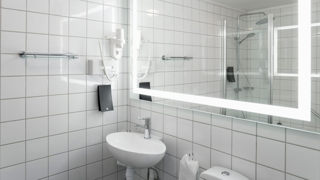 Salle de bains avec grand miroir et lavabo dans une chambre familiale et une chambre Business de Thon Hotel Skeikampen