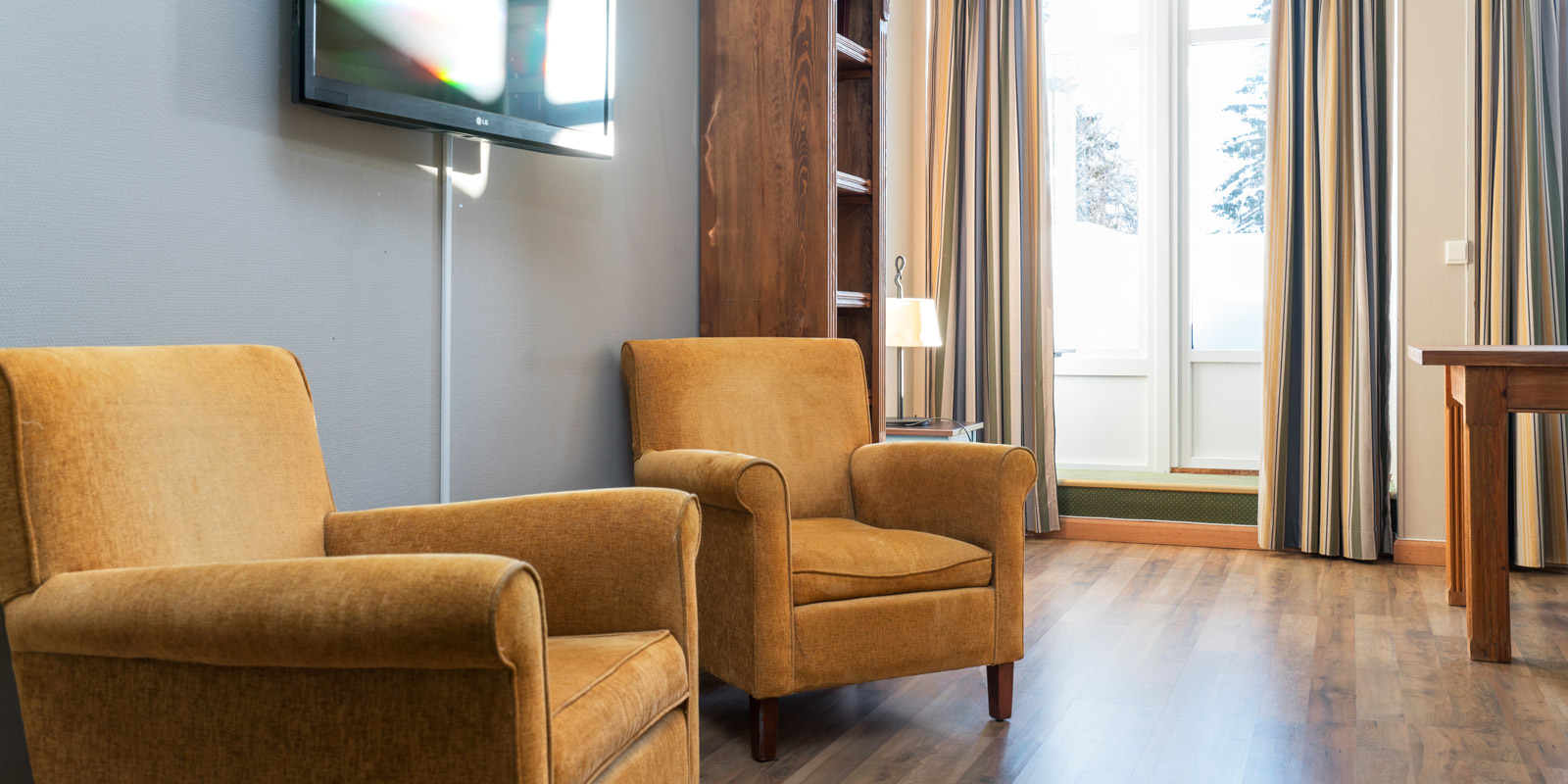 Businessroom im Thon Hotel Skeikampen: Fernseher, zwei Sessel und Veranda-Tür mit großen Fenstern