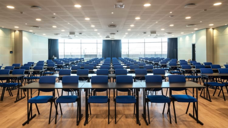 Stor konferencesal med klasseværelse-opsætning med projektor