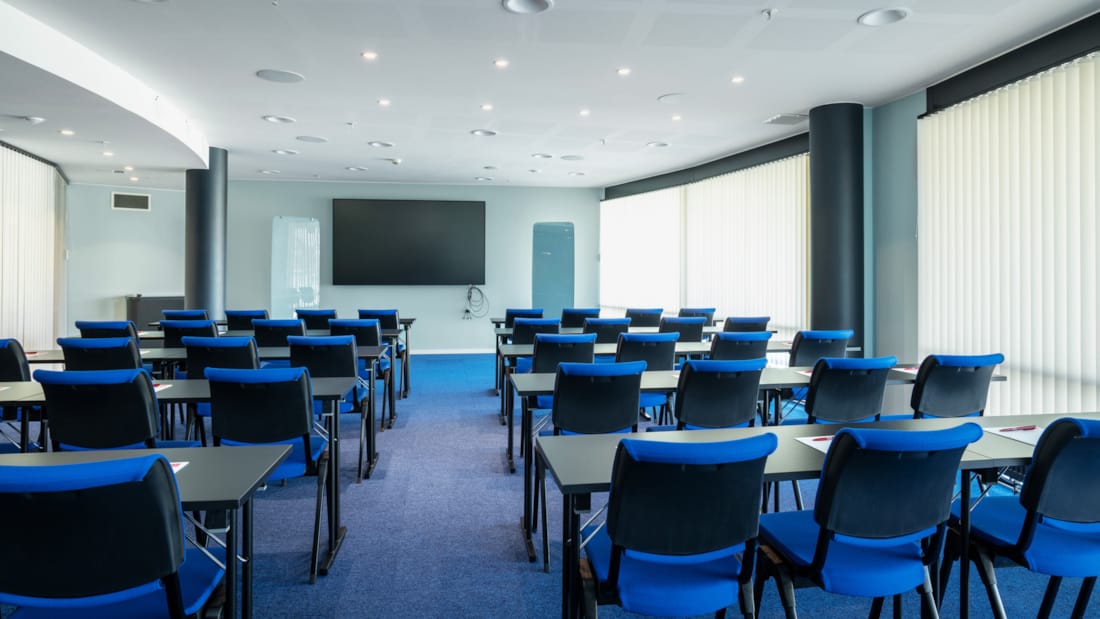 Salle de réunion en configuration salle de classe, tableau blanc et projecteur
