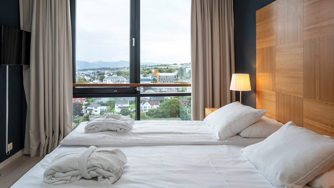 Doppelbett vor dem Fenster mit Aussicht auf eine Suite im Stavanger Forum Hotel