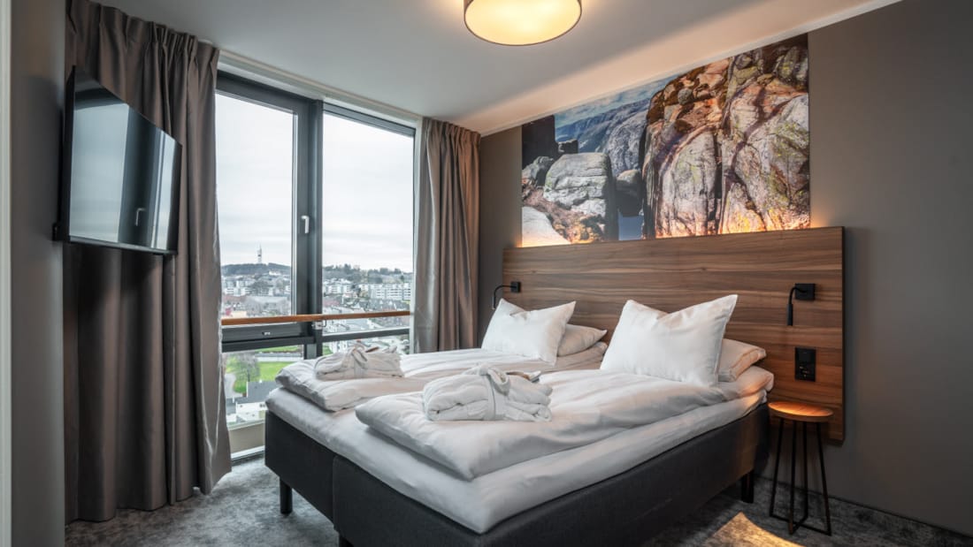Dobbeltseng foran vindue med udsigt i suite på Stavanger Forum Hotel