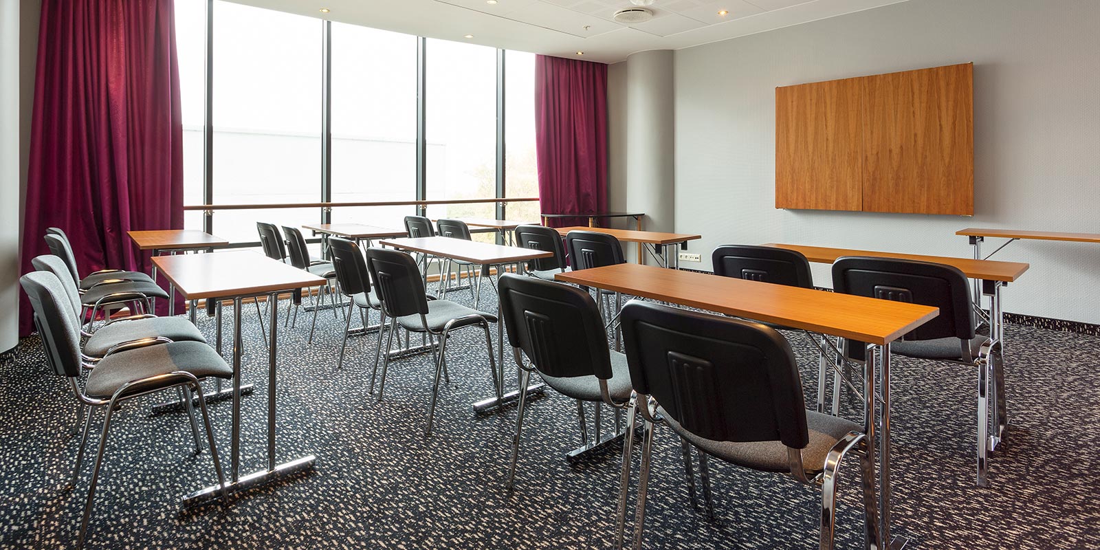 Besprechungsraum in Klassenzimmeranordnung mit großen Fenstern