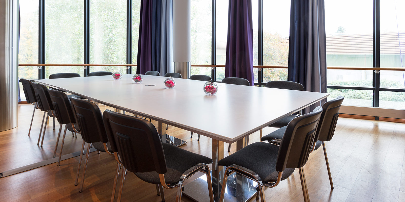 Besprechungsraum mit Steuertisch und großen Fenstern