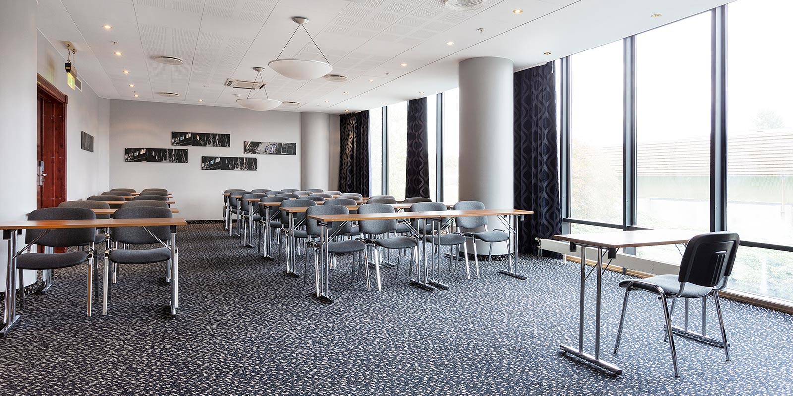 Besprechungsraum in Klassenzimmeranordnung mit großen Fenstern