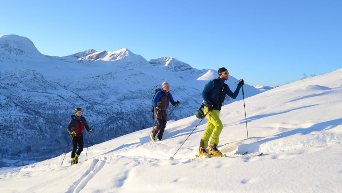 Tre personer går på ski i Kårvatn