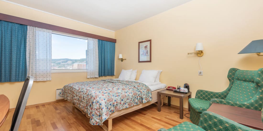 Budjettrom med dobbeltseng og sengeteppe, skrivepult, to lenestoler, garderobeskap på Hotel Surnadal