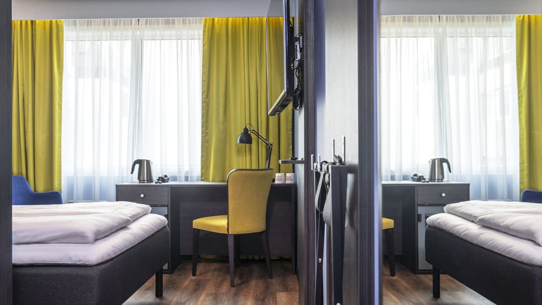 Säng och skrivbord med stol i standard dubbelrum på Thon Hotel Tromsø